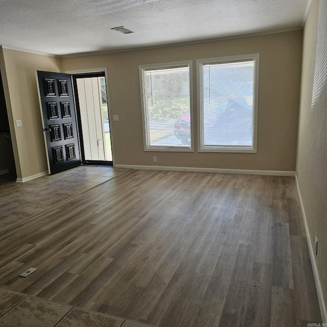 interior space featuring baseboards, visible vents, and dark wood-type flooring