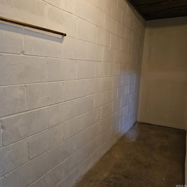 corridor featuring concrete flooring and concrete block wall