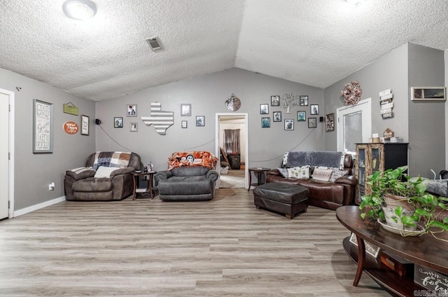 6322 US Highway 278, Rosston, AR 71858 - living room featuring light wood-style floors, vaulted ceiling, a textured ceiling, and visible vents