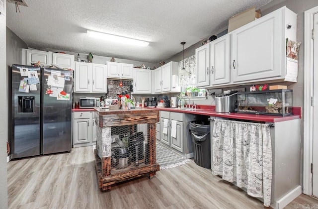 6322 US Highway 278, Rosston, AR 71858 - kitchen featuring a textured ceiling, light wood-style flooring, appliances with stainless steel finishes, and white cabinets