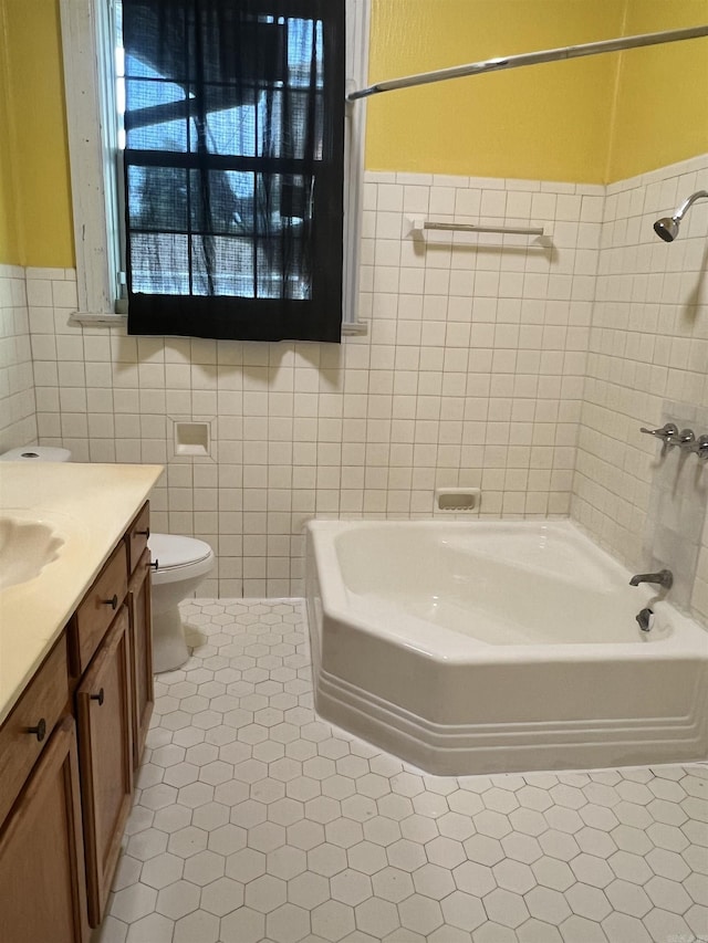 full bathroom featuring vanity, shower / bathtub combination, toilet, tile walls, and a wainscoted wall