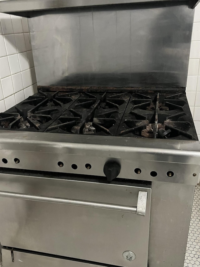 details featuring decorative backsplash and gas stove