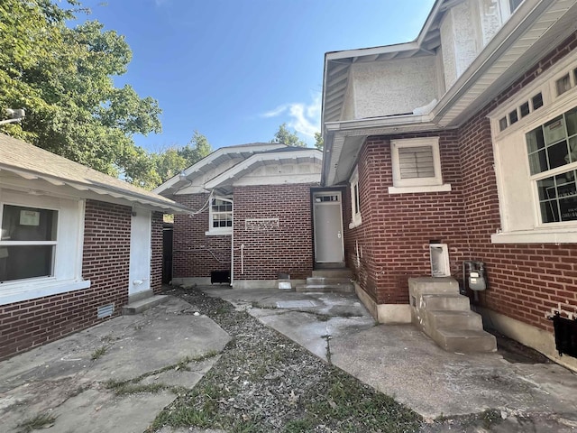 doorway to property featuring brick siding