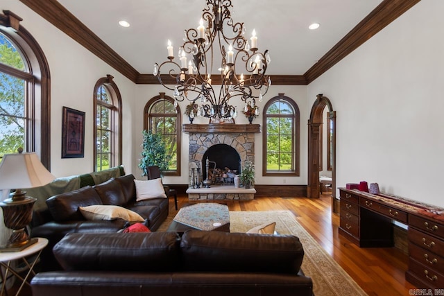 living area featuring recessed lighting, an inviting chandelier, crown molding, wood finished floors, and a fireplace