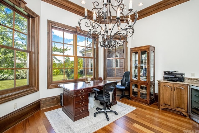 home office featuring an inviting chandelier, light wood-style flooring, crown molding, and baseboards
