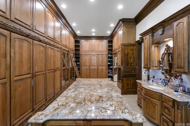 interior space featuring crown molding, vanity, and recessed lighting