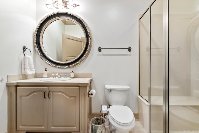 full bathroom with toilet, baseboards, a shower with door, and vanity