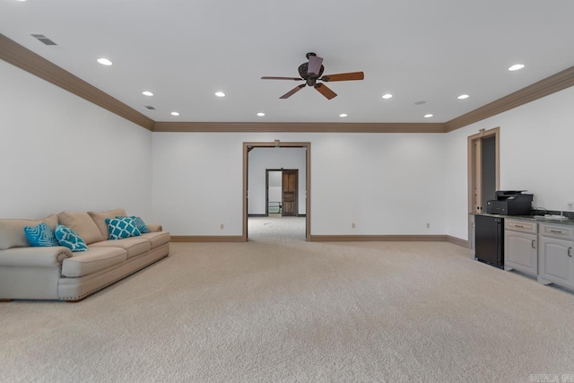 unfurnished living room with a ceiling fan, recessed lighting, baseboards, crown molding, and light carpet