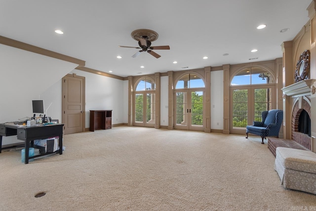living area with a ceiling fan, a wealth of natural light, and light colored carpet