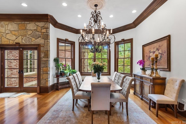 dining space with recessed lighting, light wood-style flooring, ornamental molding, and a notable chandelier