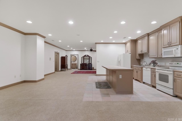 kitchen featuring white appliances, light colored carpet, crown molding, ceiling fan, and a kitchen island