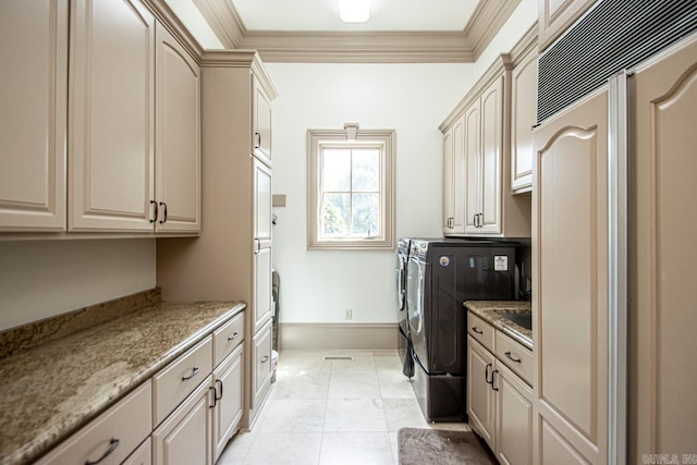 laundry room featuring cabinet space, washer and clothes dryer, baseboards, and ornamental molding