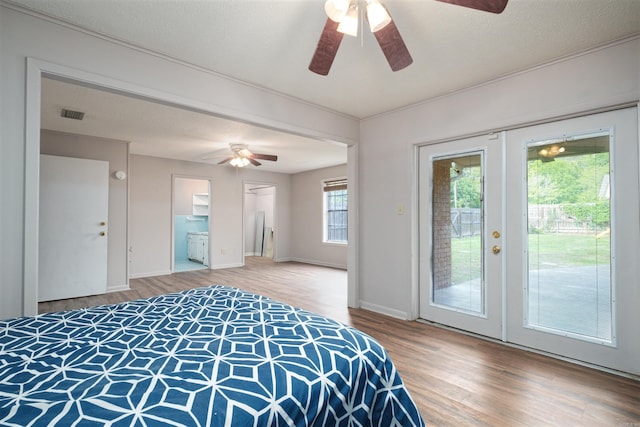 bedroom featuring french doors, wood finished floors, visible vents, baseboards, and access to outside
