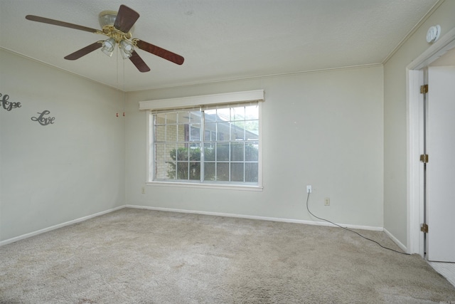 empty room with crown molding, baseboards, a ceiling fan, and carpet floors