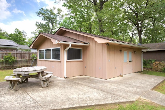 back of property featuring a patio area, outdoor dining area, and fence