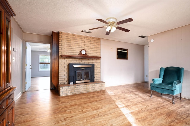 unfurnished living room with visible vents, wood finished floors, and a ceiling fan