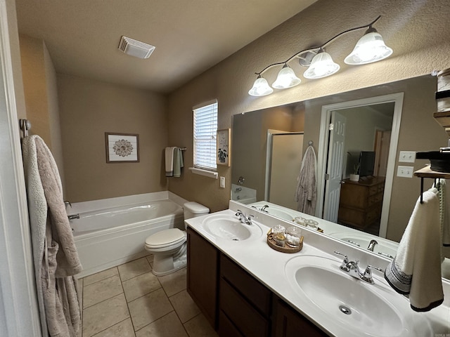bathroom with a sink, double vanity, a bath, and visible vents