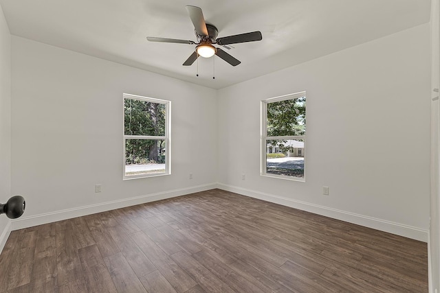 empty room featuring baseboards, a ceiling fan, and dark wood-style floors