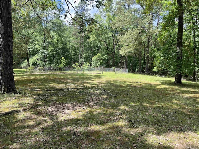 view of yard with a forest view and fence