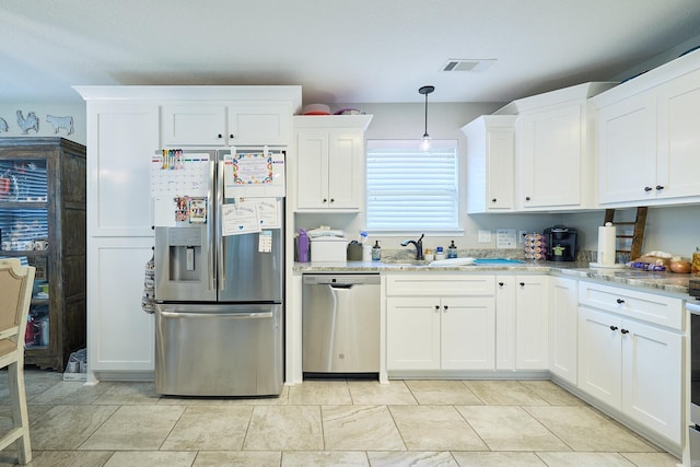 kitchen with a sink, white cabinets, visible vents, light countertops, and appliances with stainless steel finishes