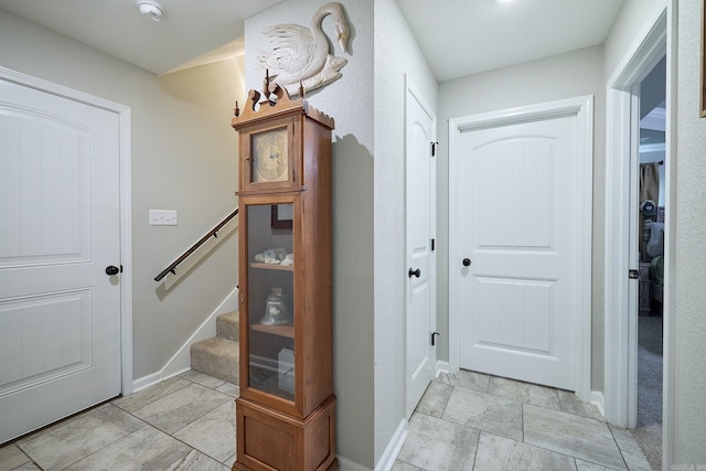doorway featuring stairway and baseboards