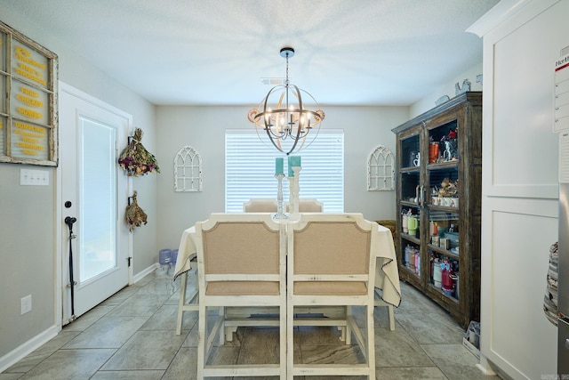 dining area featuring a chandelier and baseboards