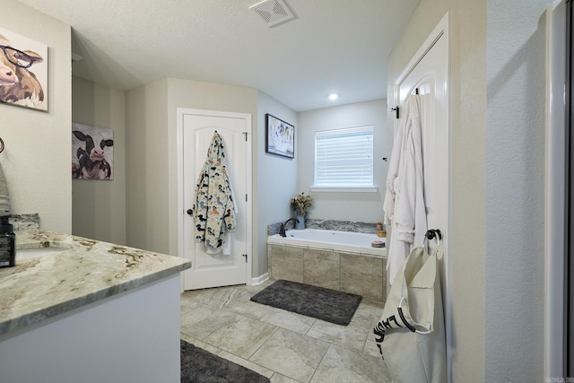 bathroom with a bath, visible vents, tile patterned flooring, and vanity