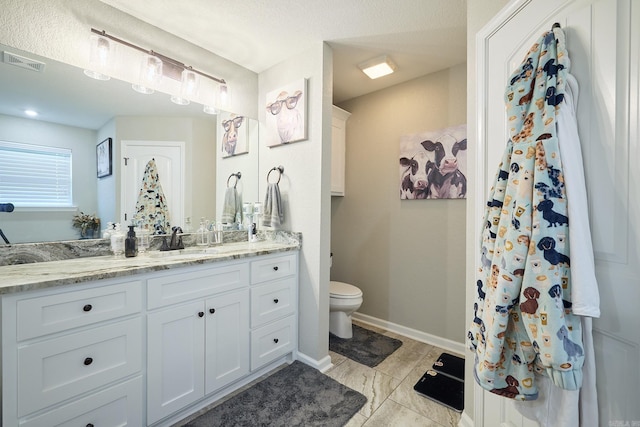 full bathroom featuring vanity, toilet, baseboards, and visible vents