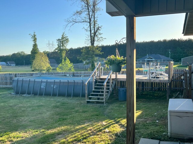 view of yard with a wooden deck, an outdoor pool, and a fenced backyard