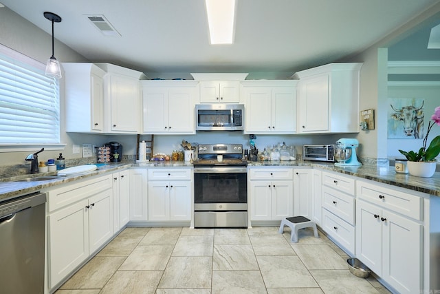 kitchen with white cabinets, stainless steel appliances, visible vents, and a sink