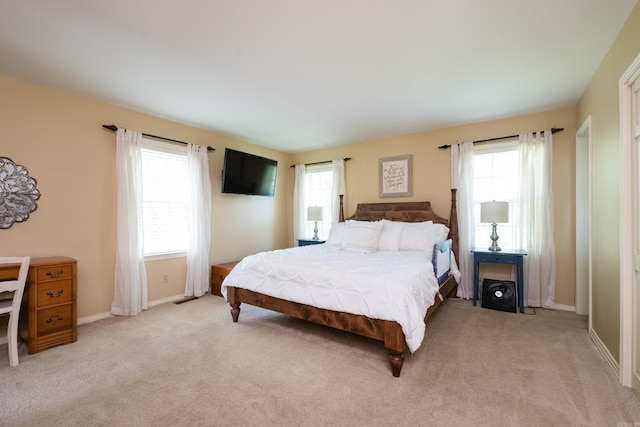bedroom with light carpet and baseboards