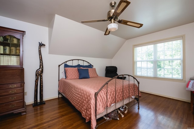 bedroom with vaulted ceiling, dark wood-type flooring, baseboards, and a ceiling fan