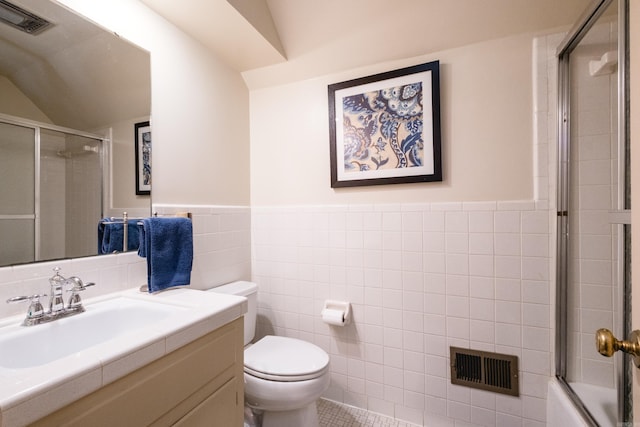 bathroom featuring vanity, toilet, tile walls, and visible vents