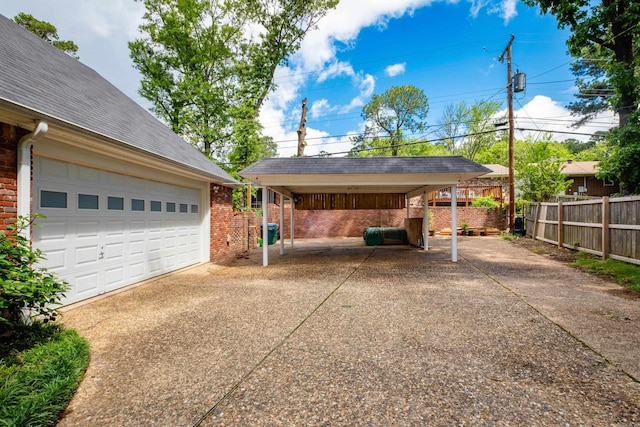 exterior space featuring driveway, fence, and a carport