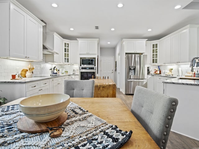 kitchen featuring decorative backsplash, stainless steel appliances, wood finished floors, and a sink
