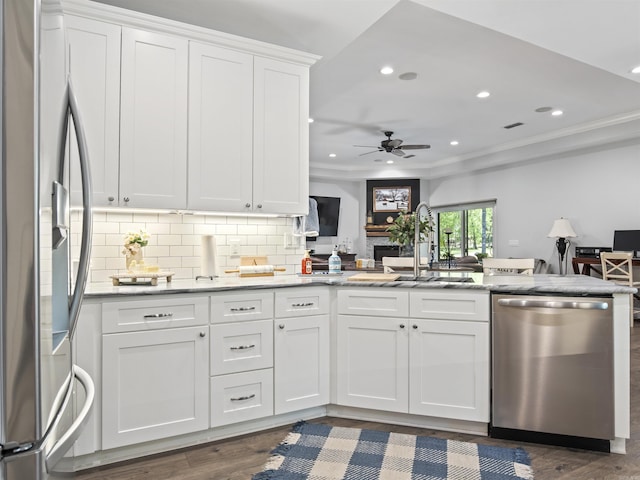 kitchen featuring a sink, open floor plan, white cabinets, dark wood-style flooring, and appliances with stainless steel finishes