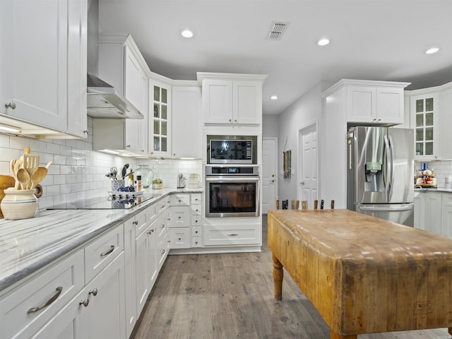 kitchen featuring white cabinets, appliances with stainless steel finishes, visible vents, and tasteful backsplash