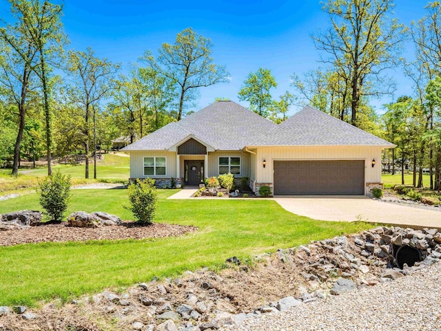view of front of property featuring driveway, roof with shingles, a garage, and a front yard