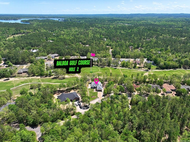 birds eye view of property featuring a wooded view and a water view