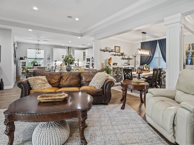 living room featuring a chandelier, ornamental molding, recessed lighting, and wood finished floors
