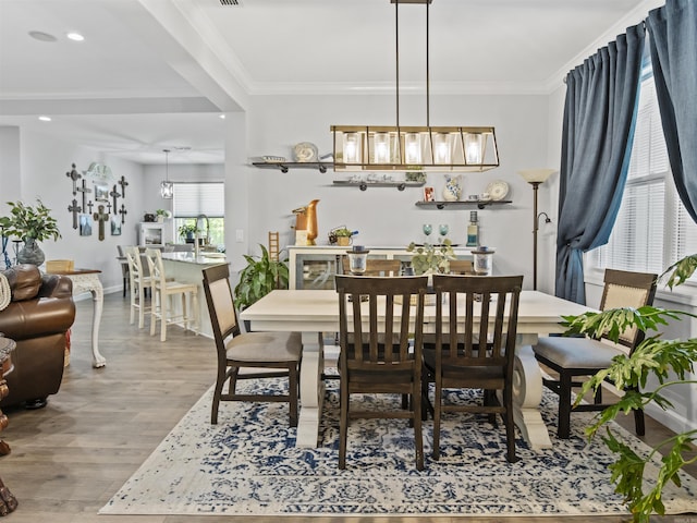 dining space featuring crown molding, wood finished floors, baseboards, and recessed lighting