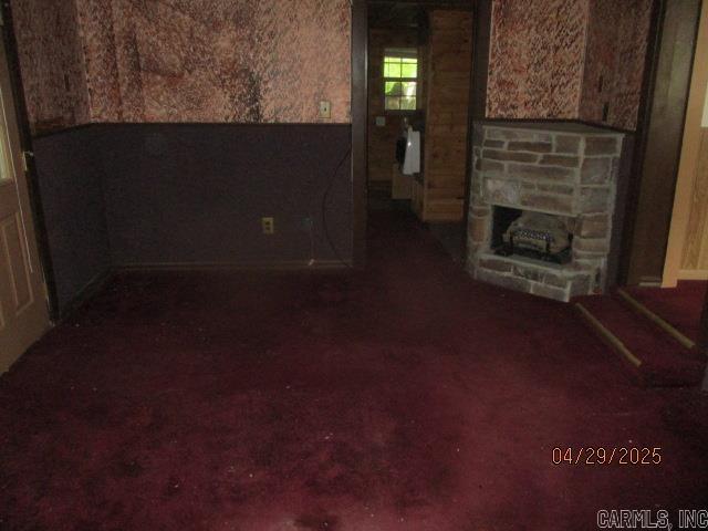 living room featuring a stone fireplace