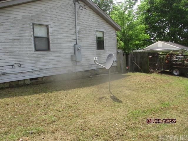 back of house with fence and a lawn