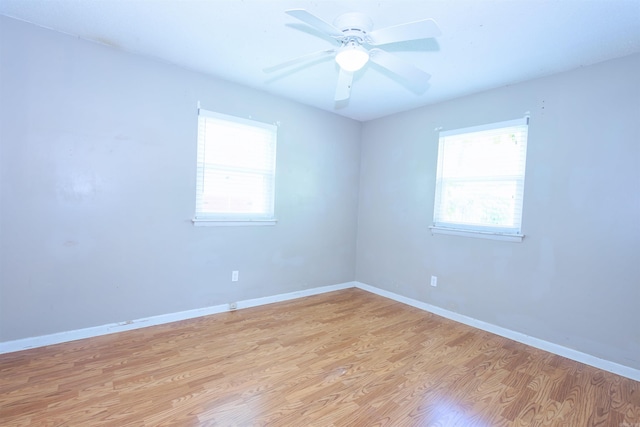 spare room featuring baseboards, light wood finished floors, and a ceiling fan