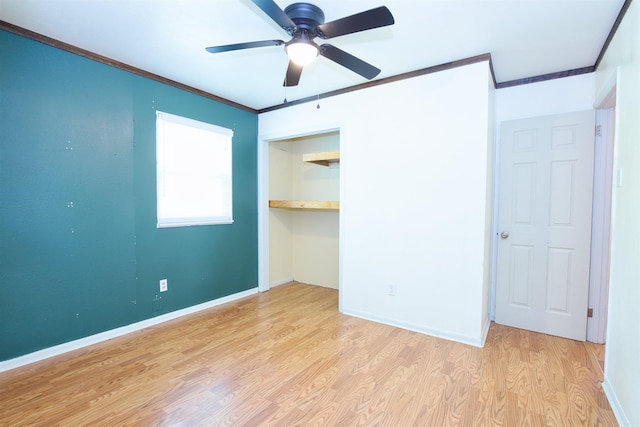unfurnished bedroom with ornamental molding, a closet, baseboards, and wood finished floors