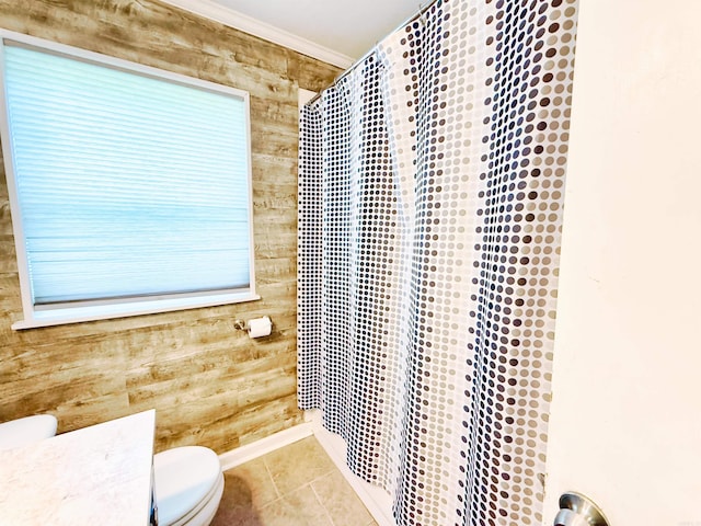 bathroom featuring toilet, tile patterned flooring, wood walls, and a shower with shower curtain