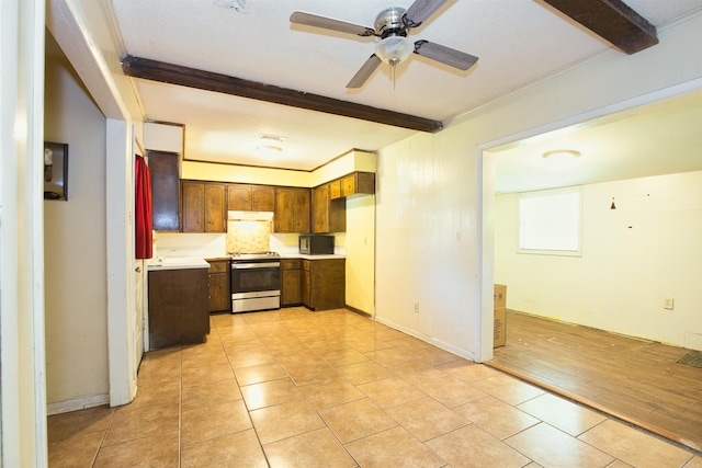 kitchen with stainless steel electric range, under cabinet range hood, light countertops, a ceiling fan, and light tile patterned floors