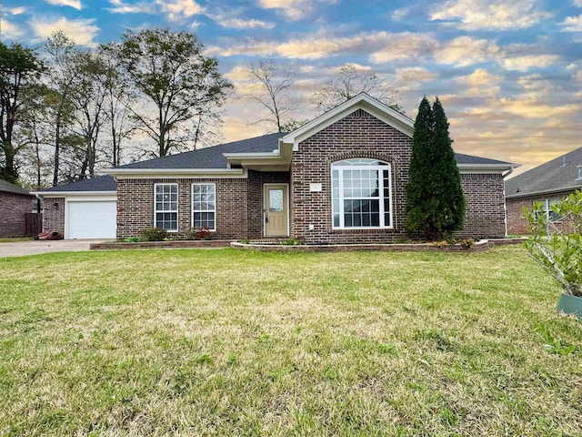 ranch-style house featuring a front lawn, brick siding, a garage, and concrete driveway