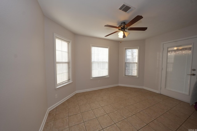 spare room with light tile patterned floors, visible vents, baseboards, and a ceiling fan