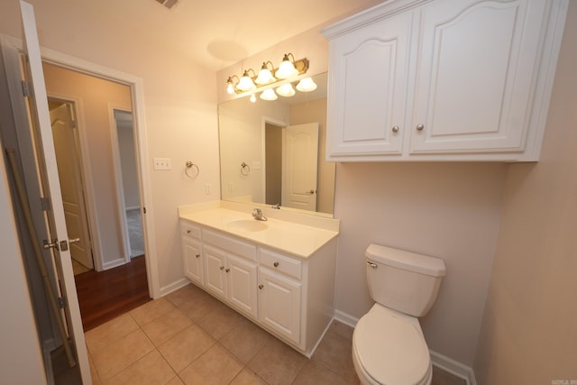 bathroom featuring toilet, baseboards, tile patterned flooring, and vanity